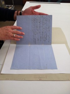 A conservator handling paper using bare hands